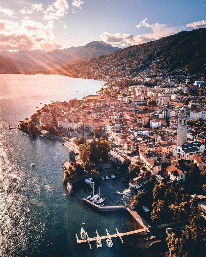 Citta di Pallanza veduta aerea, molo delle barche, monumento dei caduti. luce del mattino che illumina il paese ed il lago.